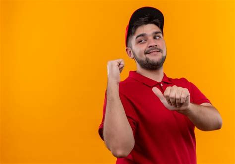 Jovem Entregador De Uniforme Vermelho E Bon Apontando Para Tr S