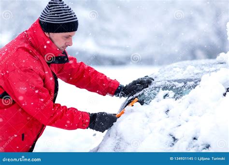 Man Removing Snow From Car Man Cleaning Snow From Car Windshield With