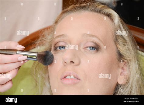 Attraktive junge hübsche blonde Frau mit Gesicht Puder Stockfotografie Alamy