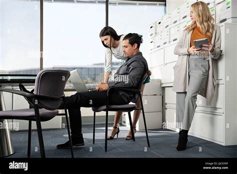 Three Co Workers Gather Around A Conference Table Stock Photo Alamy