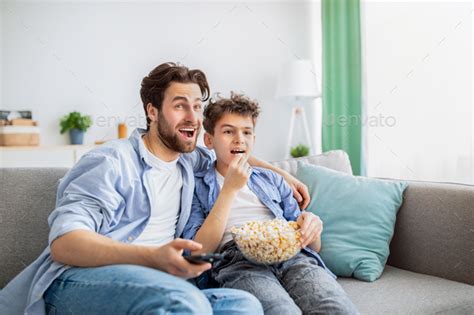 Leisure Time At Home Father And Son Watching Movie On Tv And Eating