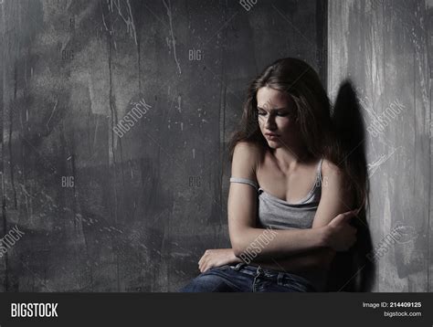 Sad Girl Sitting Against Wall