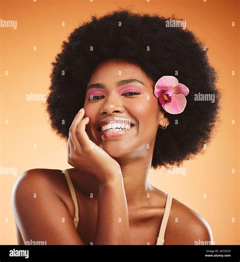 Face Beauty And Black Woman With Flower In Afro Hair On Orange Studio