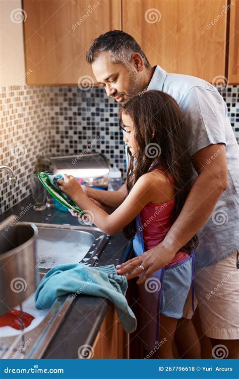 We Keep Our House Clean A Cheerful Father And Daughter Washing Dishes Together In The Kitchen