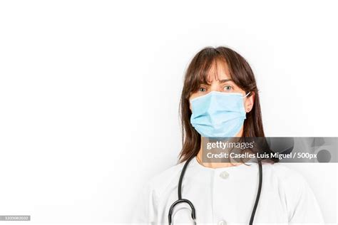 Portrait Of Female Doctor Wearing Surgical Mask Against White