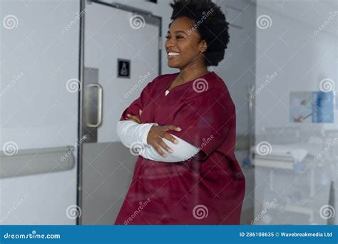 Happy African American Female Doctor Wearing Scrubs in Corridor at ...