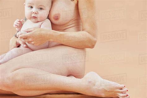 Naked Mother Bonding With Naked Baby On Lap Stock Photo Dissolve