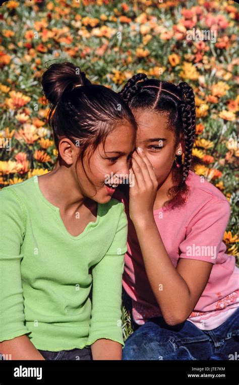 outdoorsTwo girls tell secrets whispering into ear of friend © Myrleen Pearson Stock Photo - Alamy