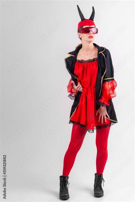 Sexy Brunette Girl In Red Tights Masquerade Costume Futuristic Glasses And Devil Horns On Her