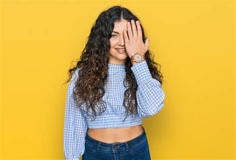 Young Hispanic Girl Wearing Casual Clothes Covering One Eye With Hand