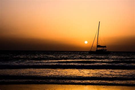 Silueta de um barco a vela ao pôr do sol Foto Premium