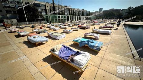 An Art Installation Of Empty Beds And A Hostage Table In Front