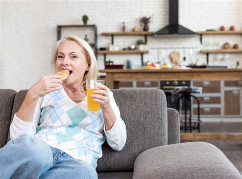 Free Photo | Medium shot woman eating on the couch