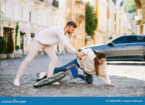 Man Helping Woman With Bicycle To Climb On Street Stock Photo Image