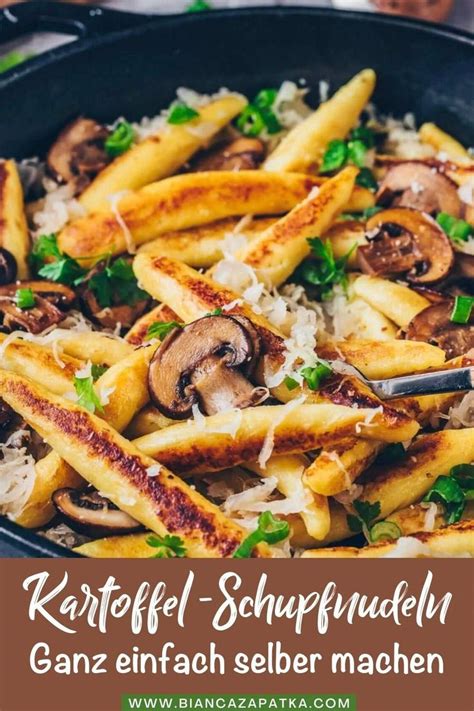 Pasta With Mushrooms And Parmesan Cheese In A Skillet On Top Of A Table