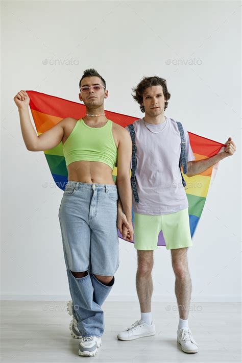 Two Gay Men Posing With Pride Flag Stock Photo By Seventyfourimages