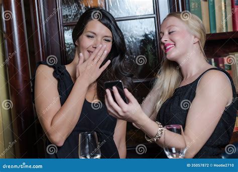 Twee Modieuze Mooie Vrouwen Die Mobiel Bekijken Stock Foto Image Of