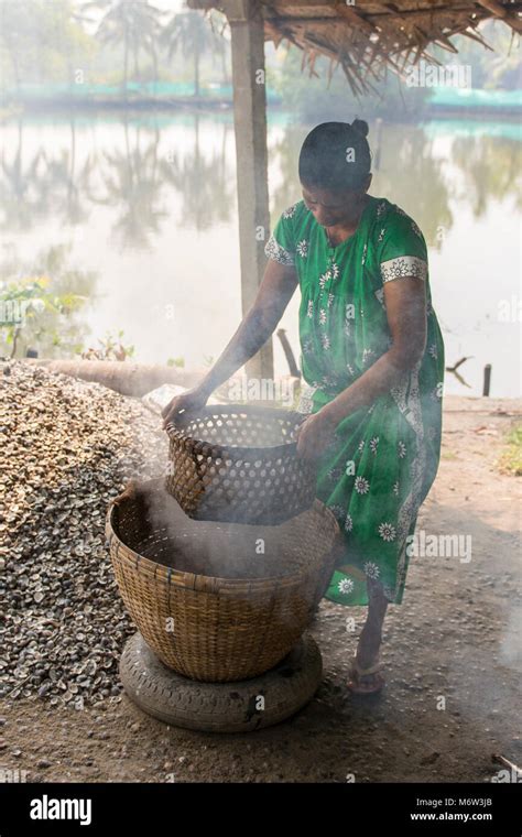 Indian Woman Straining Boiling Water From Clams In Kumbalangi Village