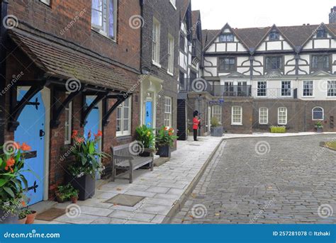 Guard Standing On A Sidewalk Next To A Cobblestone Street At The Living