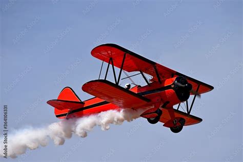 Red retro airplane (biplane) isolated on blue sky background. Vintage ...