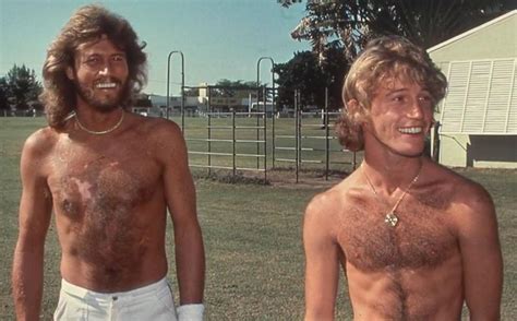 Two Men Standing In The Grass With No Shirts On