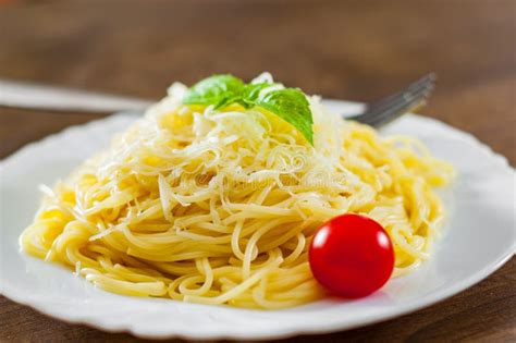 Pastas Con Queso Rallado En La Placa Blanca En La Tabla De Madera