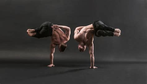Premium Photo Two Twin Brothers In Black Jeans With A Naked Torso Perform Acrobatic Elements