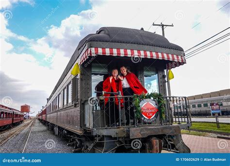 Back Of A Old Antique Railroad Train Car With Two Women Wearing Red