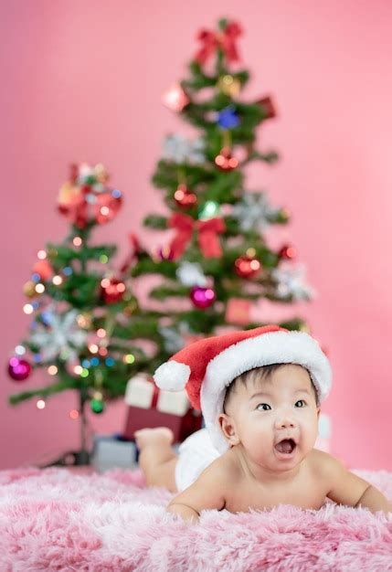 Premium Photo | Happy cute baby wearing Santa hat with Christmas pink background