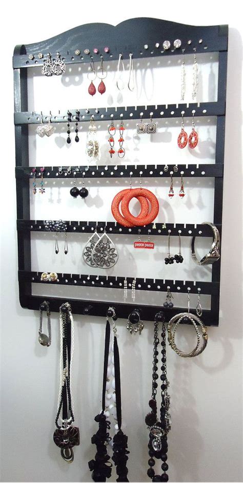 A Wall Mounted Jewelry Rack With Lots Of Necklaces And Earrings Hanging