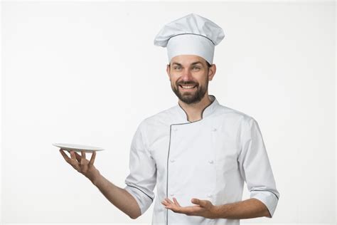 Premium Photo Smiling Male Chef Presenting His Dish Against White