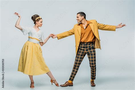 Stylish Dancers Holding Hands While Dancing Boogie Woogie On Grey