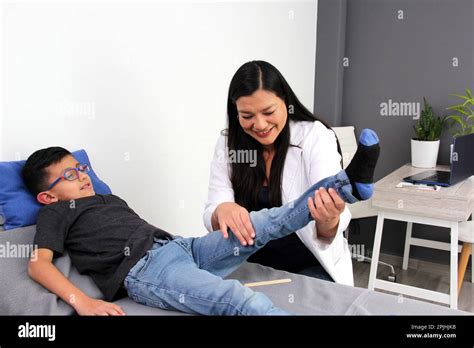 Latina Kinderärztin Ärztin besucht einen jährigen Jungen in ihrer Praxis untersucht sein Bein