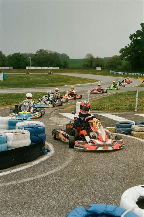 A group of people riding go karts on a track photo – Free France Image
