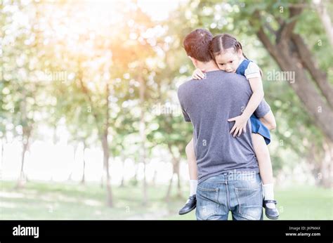 Father Carrying And Encourage His Daughter In Uniform Student On Park