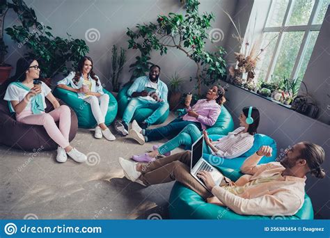 Photo Of Busy Cheerful Businessman Businesswoman Sitting Bean Bags Working Modern Devices