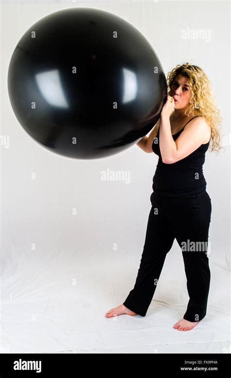 Jeune Femme Gonfler Un Ballon Noir énorme Par La Bouche Photo Stock Alamy