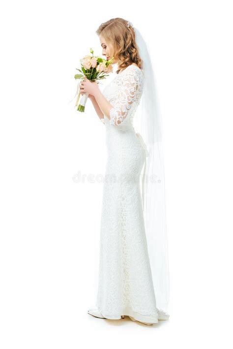 Side View Of Attractive Bride In Wedding Dress And Veil With Bouquet Of