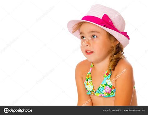 Una pequeña chica bronceada en traje de baño y sombrero fotografía