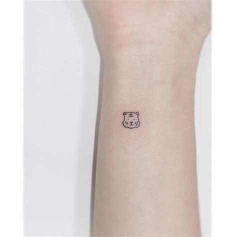 Tiny minimalistic tiger portrait tattoo located on the