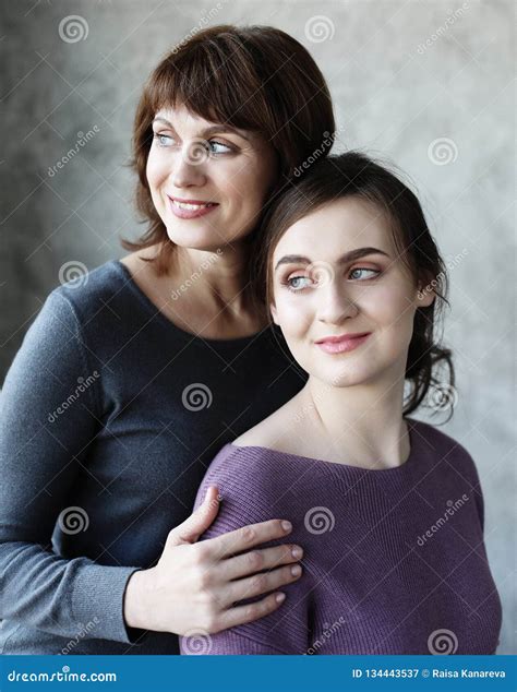 Happy Senior Mother Embracing Adult Daughter Laughing Together Stock