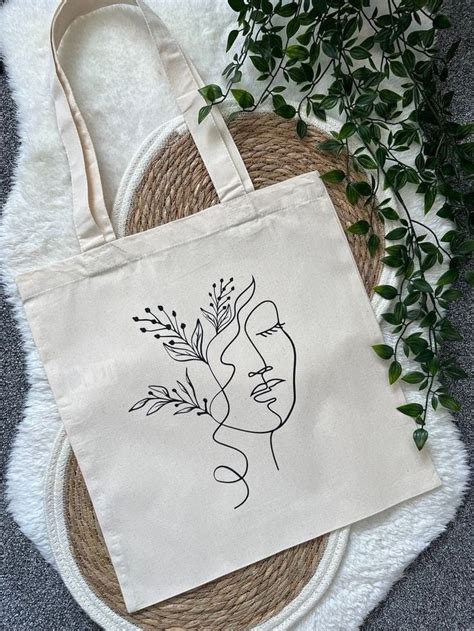 A Tote Bag Sitting On Top Of A Rug Next To A Plant