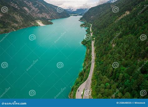 Aerial View Of A Road By Achen Lake Between Lush Green Steep Mountains