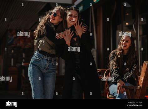 Two Girls Having Beautiful Conversation And Hugging Their Female Brunette Friend Is Looking At