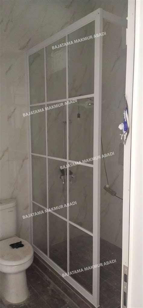 A Bathroom With A Glass Shower Door And Toilet