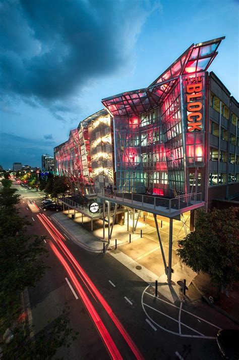 an aerial view of the exterior of a modern building at night with red ...