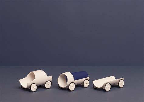 Three Wooden Toy Cars Sitting Next To Each Other On A Gray Surface With