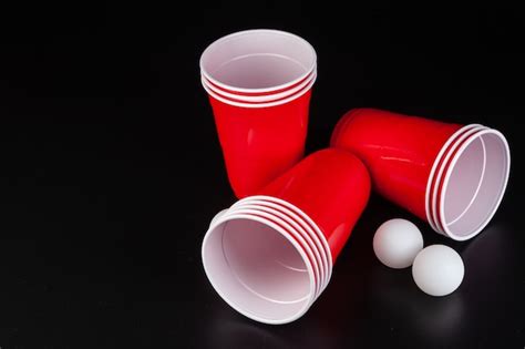 Premium Photo Red Plastic Cups And Ball For Game Of Beer Pong