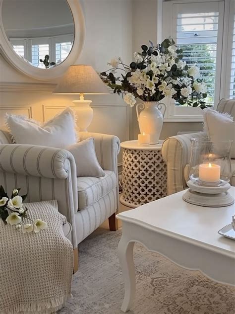 A Living Room Filled With White Furniture And Flowers