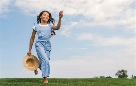 Long Shot Joyeuse Petite Fille Qui Court Sur L Herbe Photo Gratuite